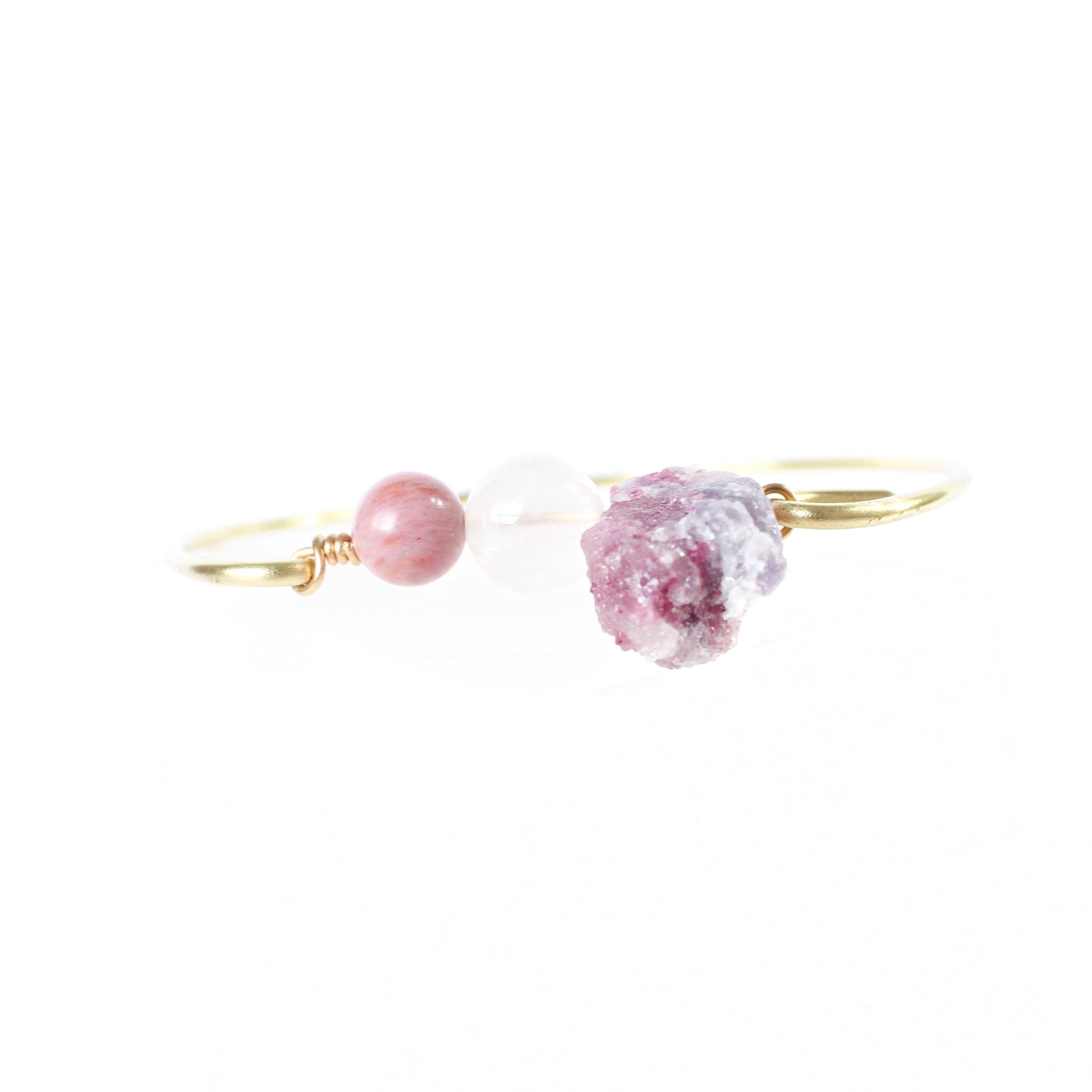 gold bangle with rhodonite, rose quartz and pink tourmaline beads in the middle. photo is taken face-on with the crystals and there is a white background 