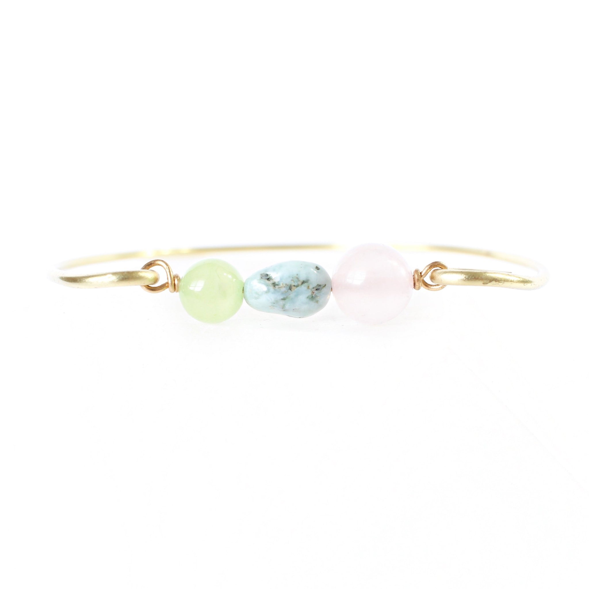 gold brass bangle with jade, larimar and rose quartz beads in the center. white background