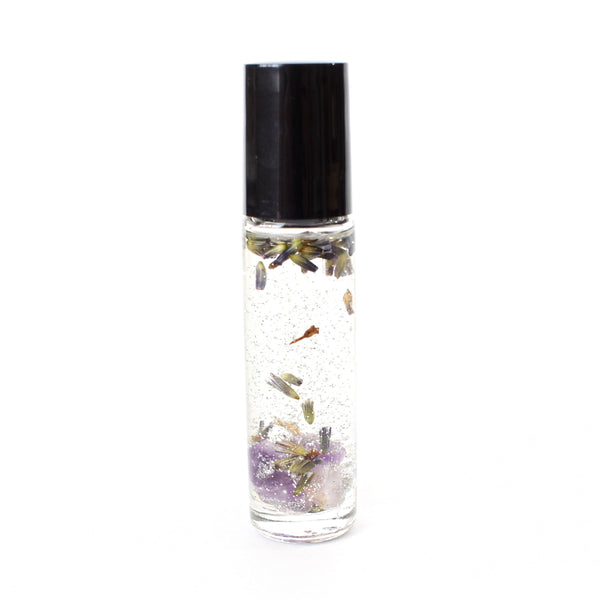 clear glass roller bottle with a black lid. bottle is filled with an essential oil blend and also contains silver glitter, dried lavender flowers, and amethyst chips. there is a white background.