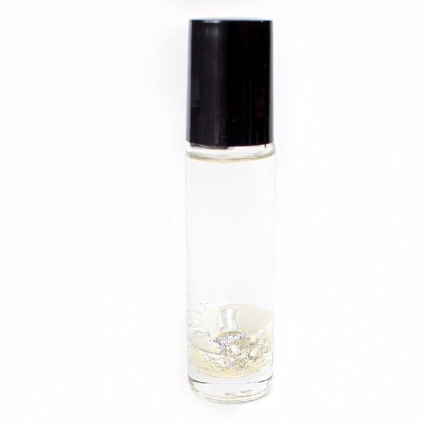 clear glass oil roller bottle with a black lid. It has a holographic Gem + Aura logo on it. The bottle is filled with oil and in it there is clear quartz, moonstone, and mother of pearl with silver glitter. white background