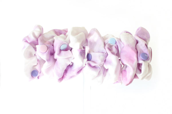 row of purple and white tie dyed scrunches with snaps to open the pocket