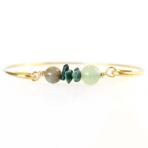 gold bangle with labradorite, malachite and green aventurine beads in the middle. bracelet is shown face-on with the crystals and has a white background