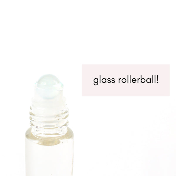 clear glass roller bottle with a close up of the frosted glass roller ball in it. white background.