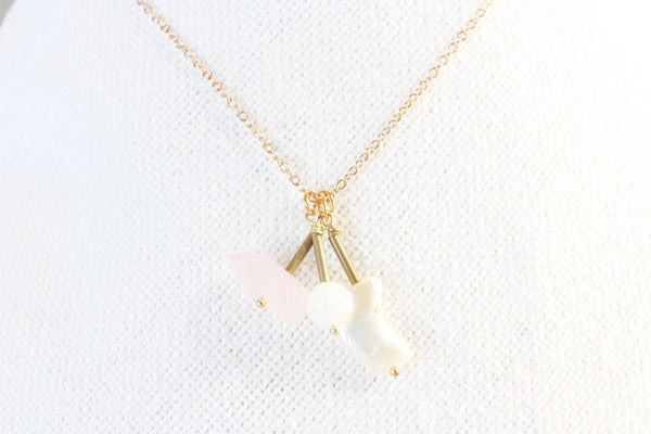 pearl moon, moonstone, and rose quartz pendants with gold brass detail, strung on a dainty gold chain