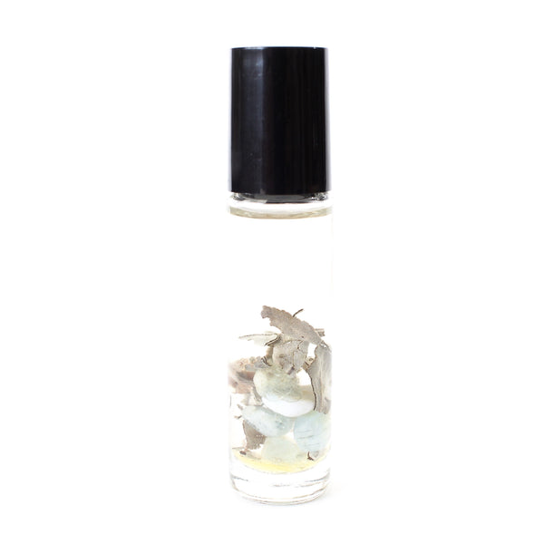 clear glass oil roller bottle with a black lid. it has a holographic gem and aura label on it. the bottle is full of oil, and inside is dried sage, aquamarine, blue lace agate and clear quartz chips. white background.