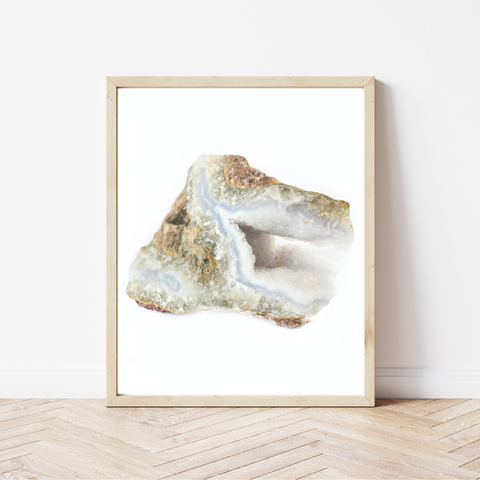 high quality photo of a blue lace agate crystal with a white background in a light wood frame, sitting on a white washed wood floor and leaning against a white wall