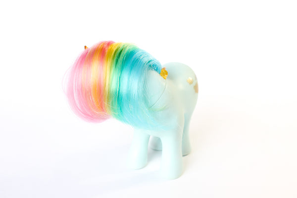 mint blue my little pony figurine with a rainbow coloured mane, an orange crystal horn and crystals trailing down her mane. white background, side profile (side of rainbow mane)