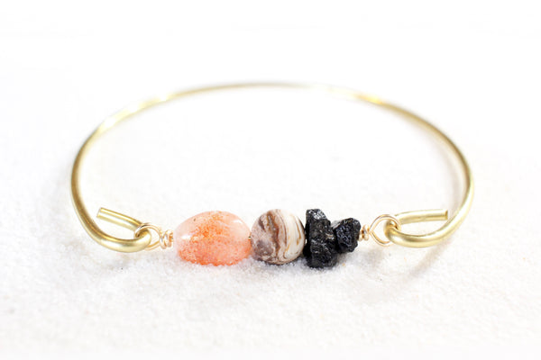 sunstone, petrified wood, and black tourmaline on a gold brass bangle